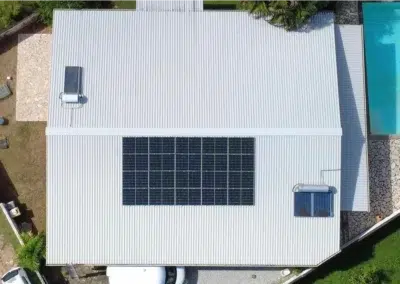 Installation de panneaux solaires sur une maison à toit blanc avec piscine en Guyane