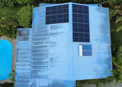 Panneaux solaires noirs sur une toiture saumon d’une maison en Guyane