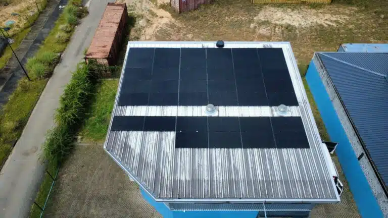 Panneaux solaires sur la toiture d'un bâtiment professionnel à Matoury, installation de 20 kWc (2026), vue aérienne verticale