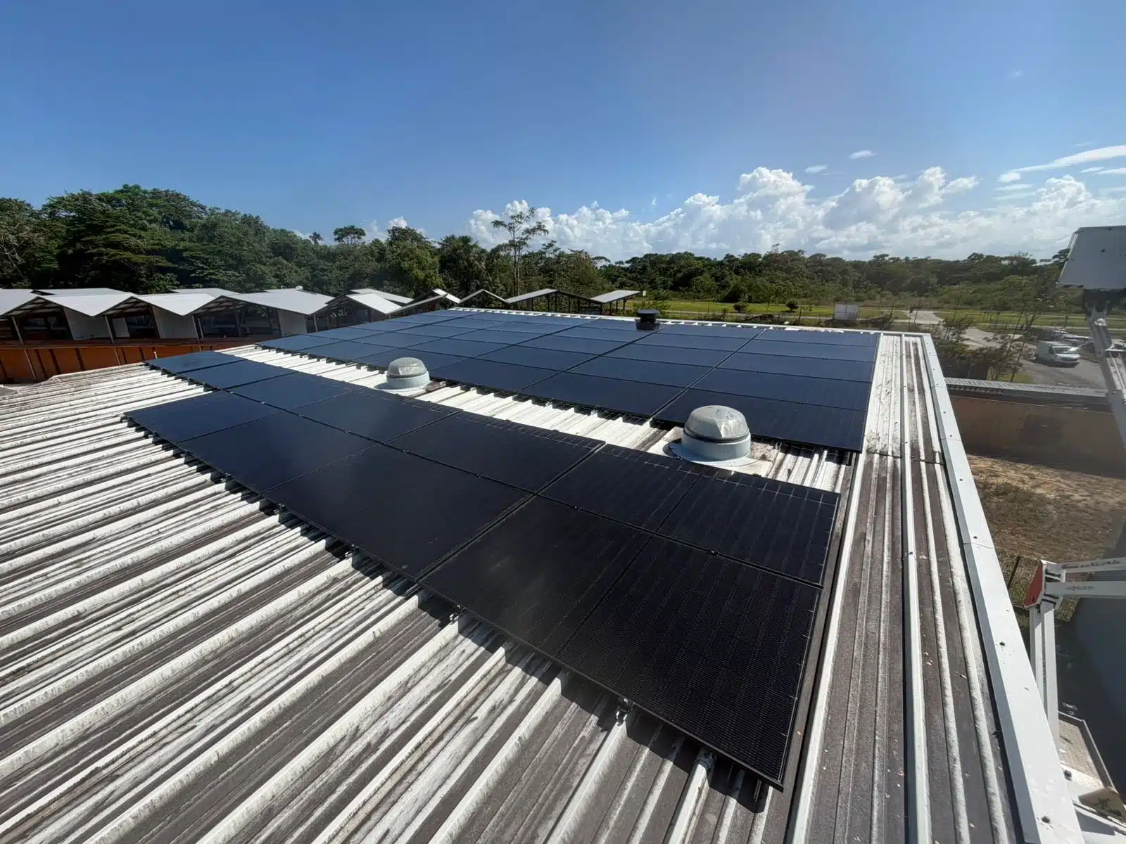 Panneaux solaires posés sur la toiture en tôle du bâtiment, sous le ciel de Matoury